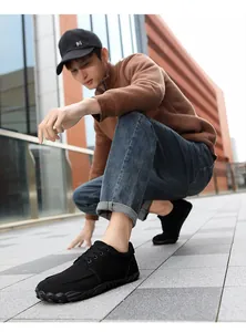 Side view of black mesh outdoor hiking shoes on male model in urban setting
