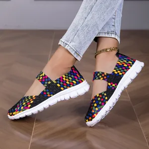 Close-up of colorful woven elastic sandals on model showing the vibrant checker pattern