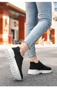 Detailopname van ademende zwarte gebreide sneakers met een getextureerde witte zool