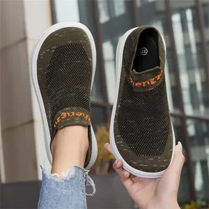 Close-up of olive green breathable flyknit slip-on sneakers with orange detailing