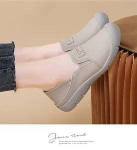 Detailopname van beige lederen slip-on loafers met zachte zool en sportlabel