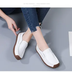 Detailed view of comfortable white leather loafers with breathable holes on grey background