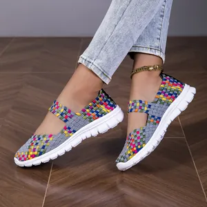 Detailed shot of colorful hand-woven elastic strap sneakers for women on wooden floor