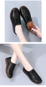 Detailed view of women's black soft leather flat shoes worn on feet with slip-on design