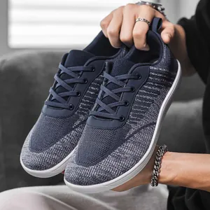 Detail view of breathable navy blue fly-knit sneakers with wide toe and white sole