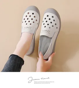 Detail van witte geperforeerde leren slip-on schoenen met grijze accenten en zachte zool