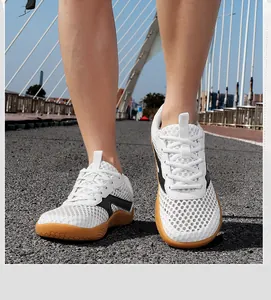 Close-up of white breathable mesh sneakers with wide toe box and gum rubber soles.