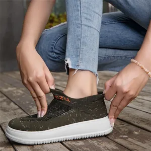 Close-up detail of breathable olive green flyknit slip-on sneaker on wooden deck