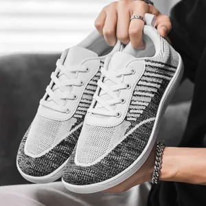 Detailed macro view of the breathable knit fabric and wide-toe design on grey barefoot sneakers.