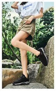 Modella asiatica con scarpe da trekking nere traspiranti in un ambiente forestale