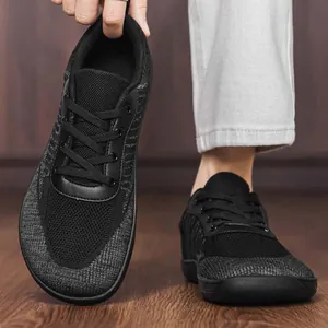 Detail of breathable mesh upper and wide toe box design on black barefoot shoes.