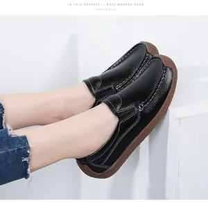 Side view of black genuine leather loafers with white stitching and gum sole