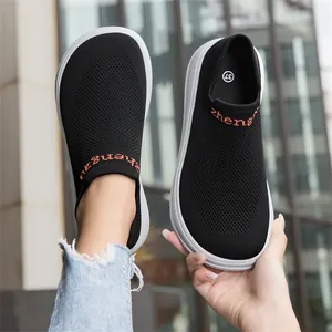 Detailed shot of black fly-knit slip-on sneaker with wide-toe design and white sole
