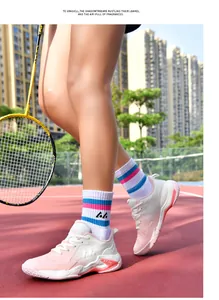 Chaussures de badminton professionnelles roses et blanches sur terrain extérieur.