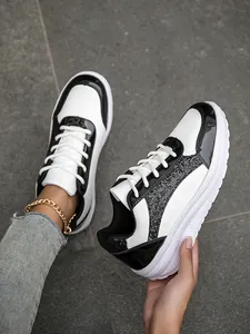 Detailed view of women's black and white platform sneakers with sparkling sequin accents