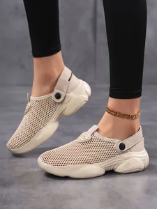 Close-up of beige breathable mesh mule sneakers with thick platform sole on foot