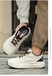 Close-up detail of wide toe box mountain trail running shoes in cream and brown.