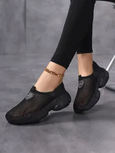Close-up of breathable black mesh slip-on shoes on a model featuring thick non-slip soles