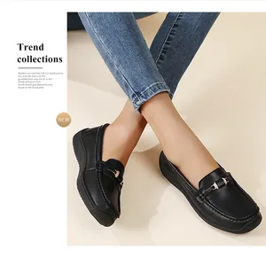 Vue rapprochée de mocassins en cuir noir pour femmes avec une boucle dorée élégante