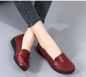Close-up detail of stylish red perforated loafers featuring elegant white stitching
