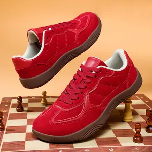 Retro red suede Gat sneakers with brown gum sole on creative chessboard background