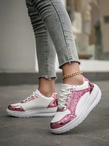 Close-up of stylish white sneakers with pink glitter and metallic finish details