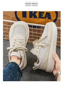 Detailed close-up of breathable beige mesh sneakers with wide toe box and chunky sole for men