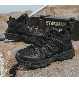 Détail latéral de chaussures de randonnée noires robustes sur terrain rocheux.