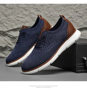 Detail view of navy fly-knit business casual shoes with brown leather accents and white soles.