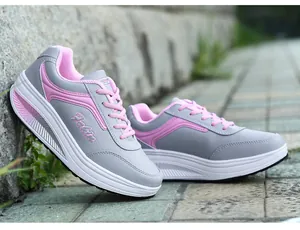 Close-up of grey and pink women's rocking shoes with thick platform soles in outdoor setting