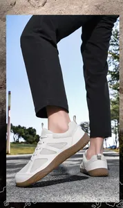 Detalle de zapatillas de malla blanca transpirable con suela de goma marrón flexible