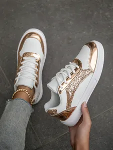 Detailed view of fashionable white sneakers featuring rose gold sequins and metallic finish