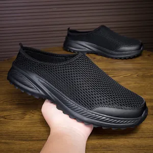 Close-up detail of lightweight breathable black mesh slip-on sneakers for men on wooden surface