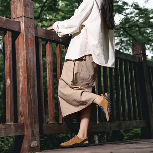 Chaussures de randonnée en daim marron avec lacets bleus dans un cadre forestier naturel.