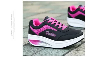 Close-up of black and pink women's rocking platform sneakers with thick white soles.