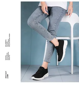 Detail view of black platform sneakers worn by a model sitting on a white chair.