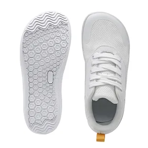Detail view of white sneakers showing breathable mesh upper and anti-slip rubber outsole.