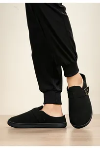 Close-up view of black warm Birkenstock style clogs with adjustable metal buckle strap