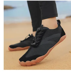 Primo piano di scarpe da spiaggia nere traspiranti con suola in gomma sulla sabbia