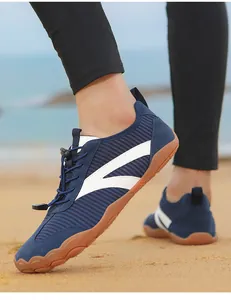 Primo piano di scarpe da scoglio blu traspiranti per uomo e donna su una spiaggia sabbiosa
