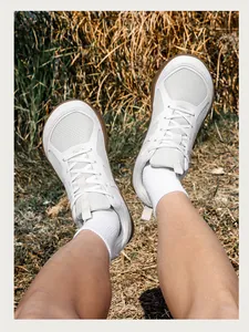 Vista detallada de zapatos de senderismo blancos con punta ancha en un entorno natural
