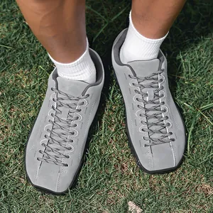 Vue de dessus détaillée de chaussures de randonnée grises à bout large sur l'herbe