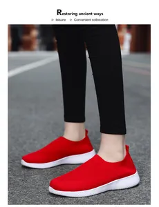 Close-up of red breathable fly-knit slip-on walking shoes on feet outdoors
