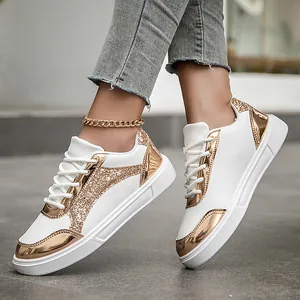 Stylish women's white sneakers featuring gold metallic accents and glitter patches