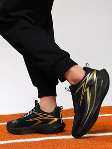 Close-up of professional carbon plate running shoes in black and gold on a track