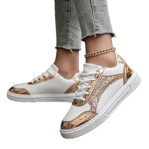 Fashionable women's white sneakers featuring gold glitter and metallic mirror accents.