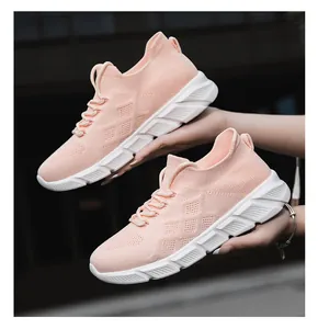 Detail view of pink knit women's sneakers with chunky white platform sole, held by hand