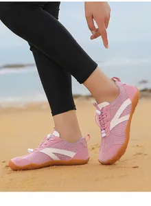 Primo piano di scarpe da scoglio rosa traspiranti per spiaggia e sport acquatici