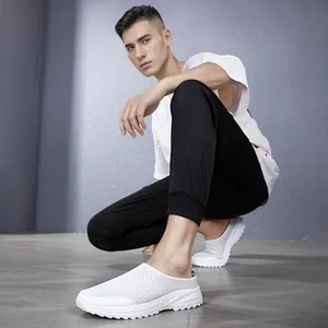 Low-angle detail of white fly-knit breathable slip-on men's casual sneakers.