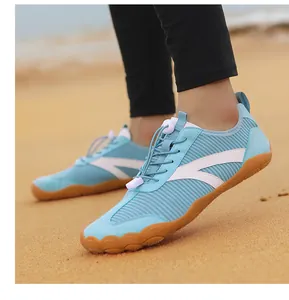 Vista dettagliata delle scarpe da scoglio blu chiaro traspiranti su una spiaggia di sabbia